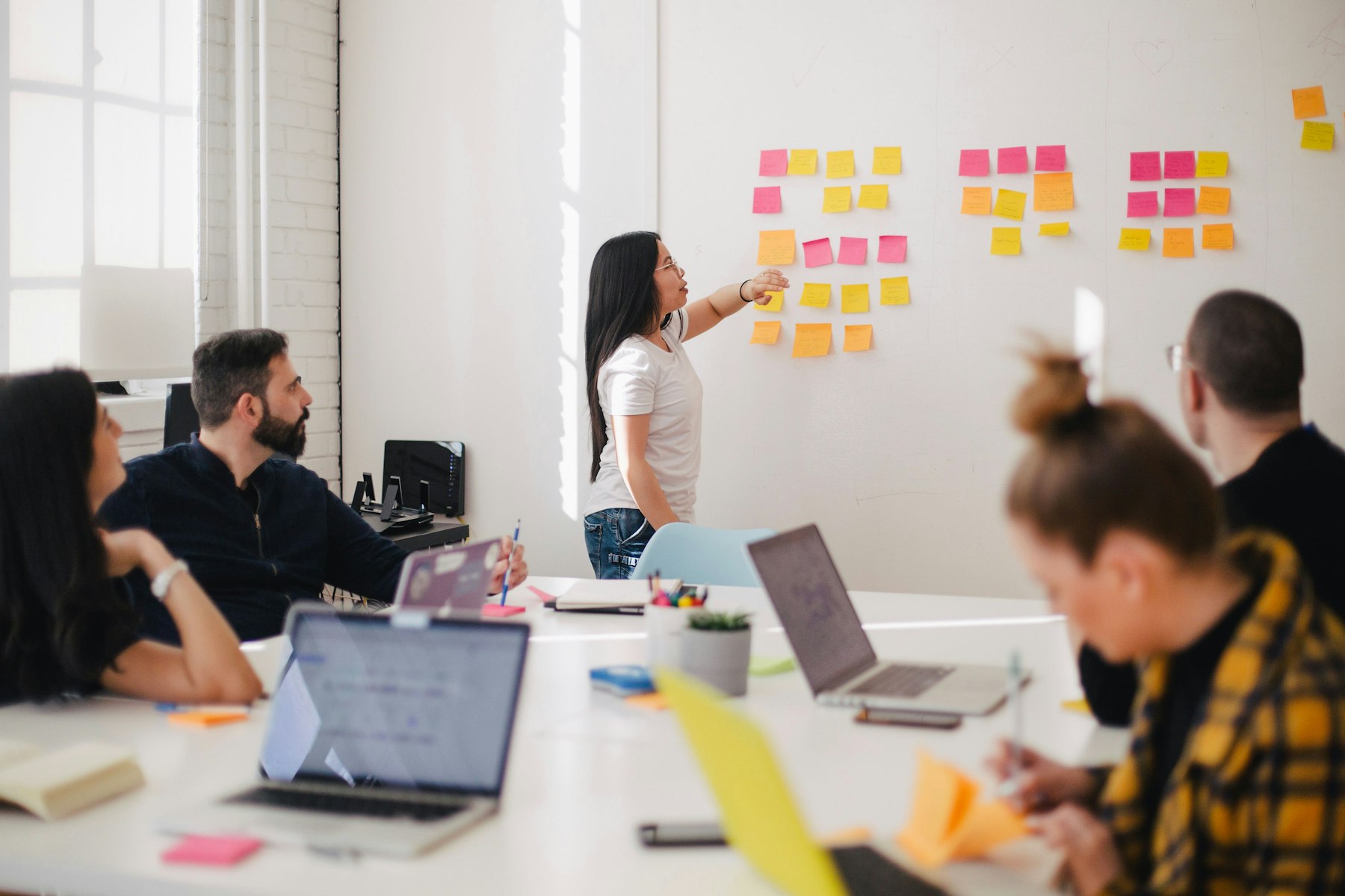 A team sorting colour-coded notes on a wall during a planning session